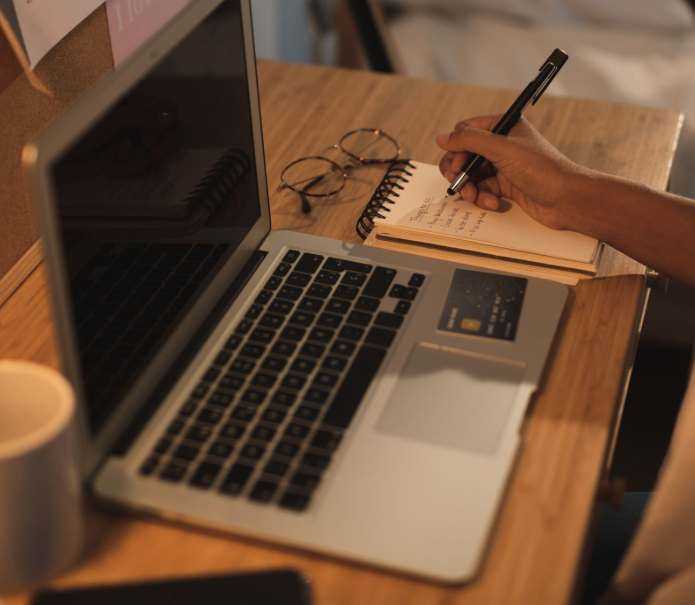 Blog writer brainstorming ideas with notebook and laptop showing content outline